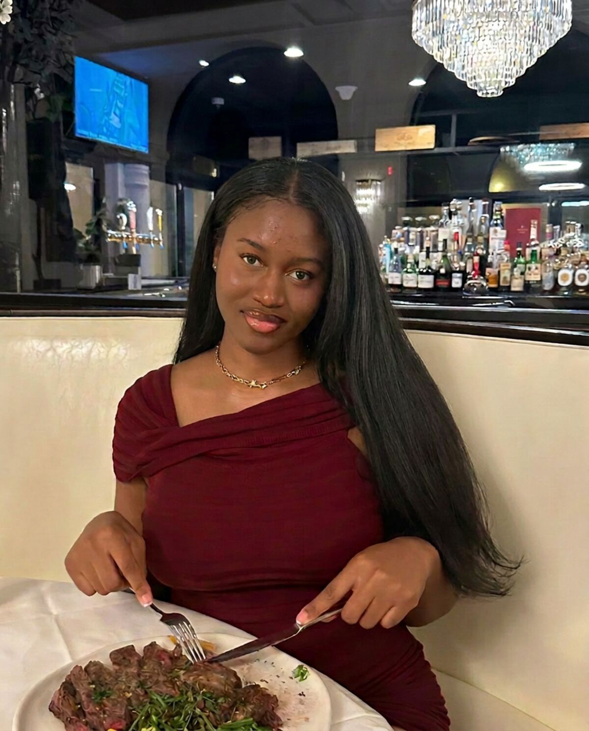 Aduwa smiling at a candlelit dinner